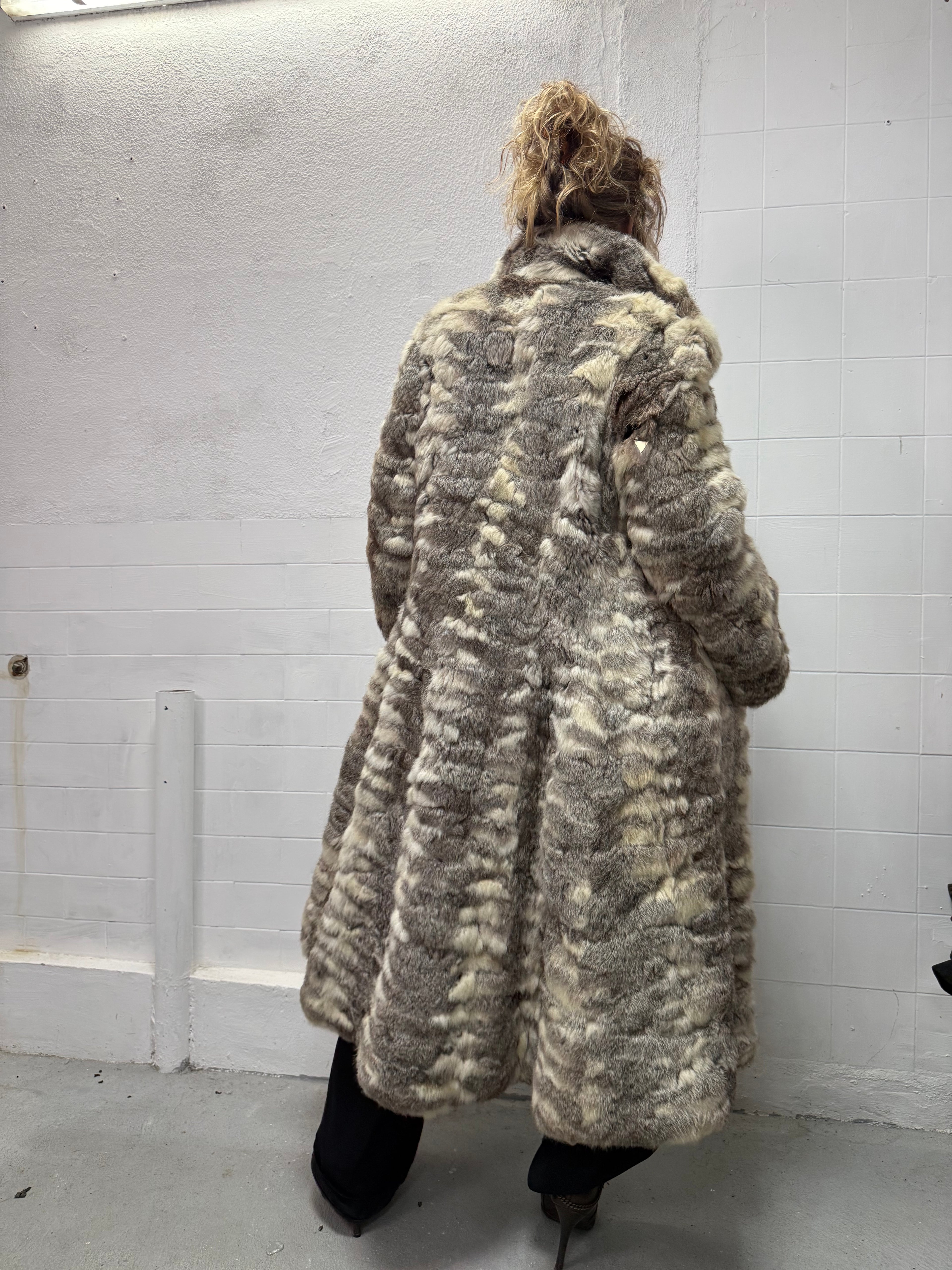 Full length real fur coat styled with black trousers, back view