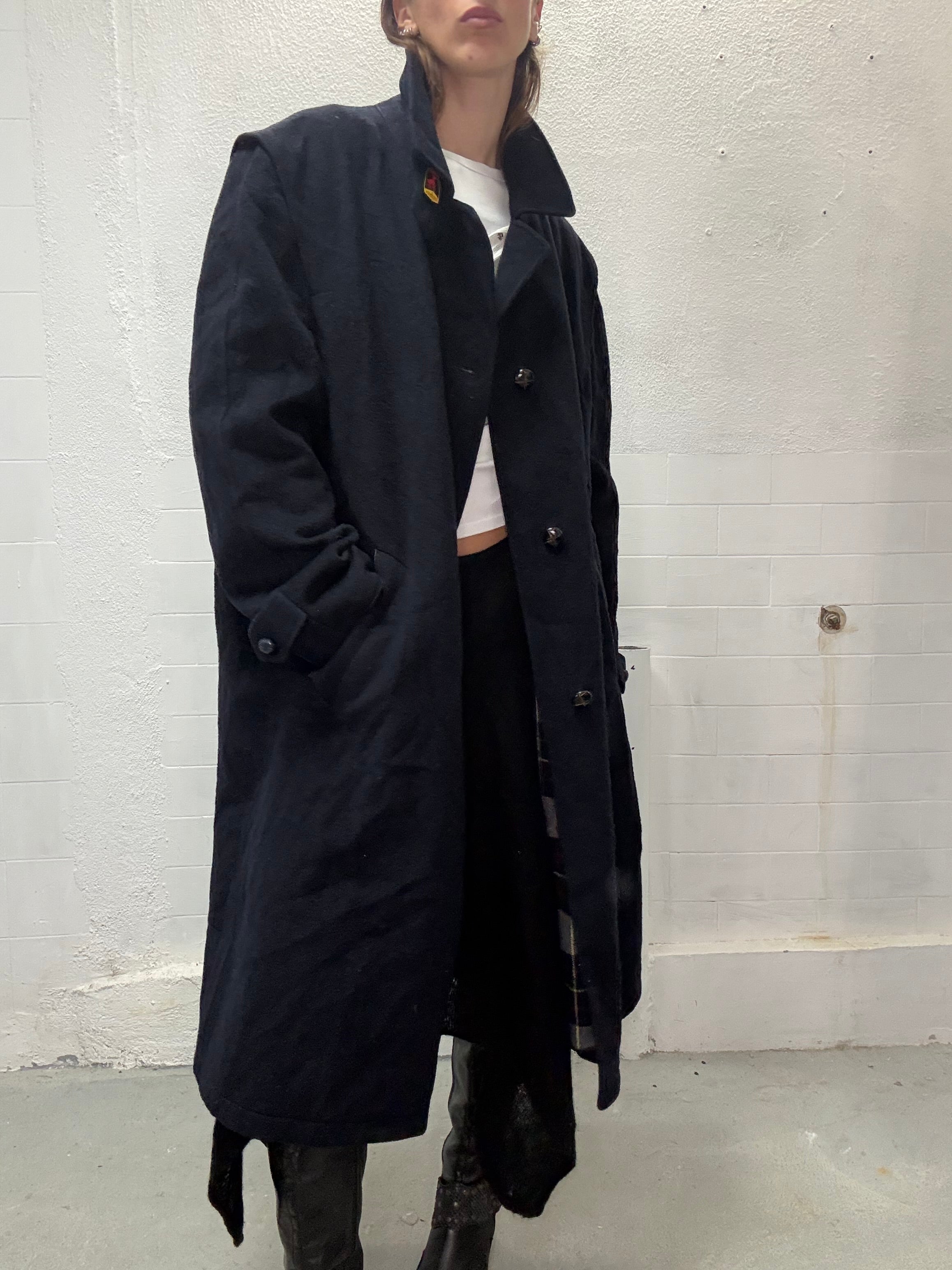 Full-length navy wool coat styled with black boots