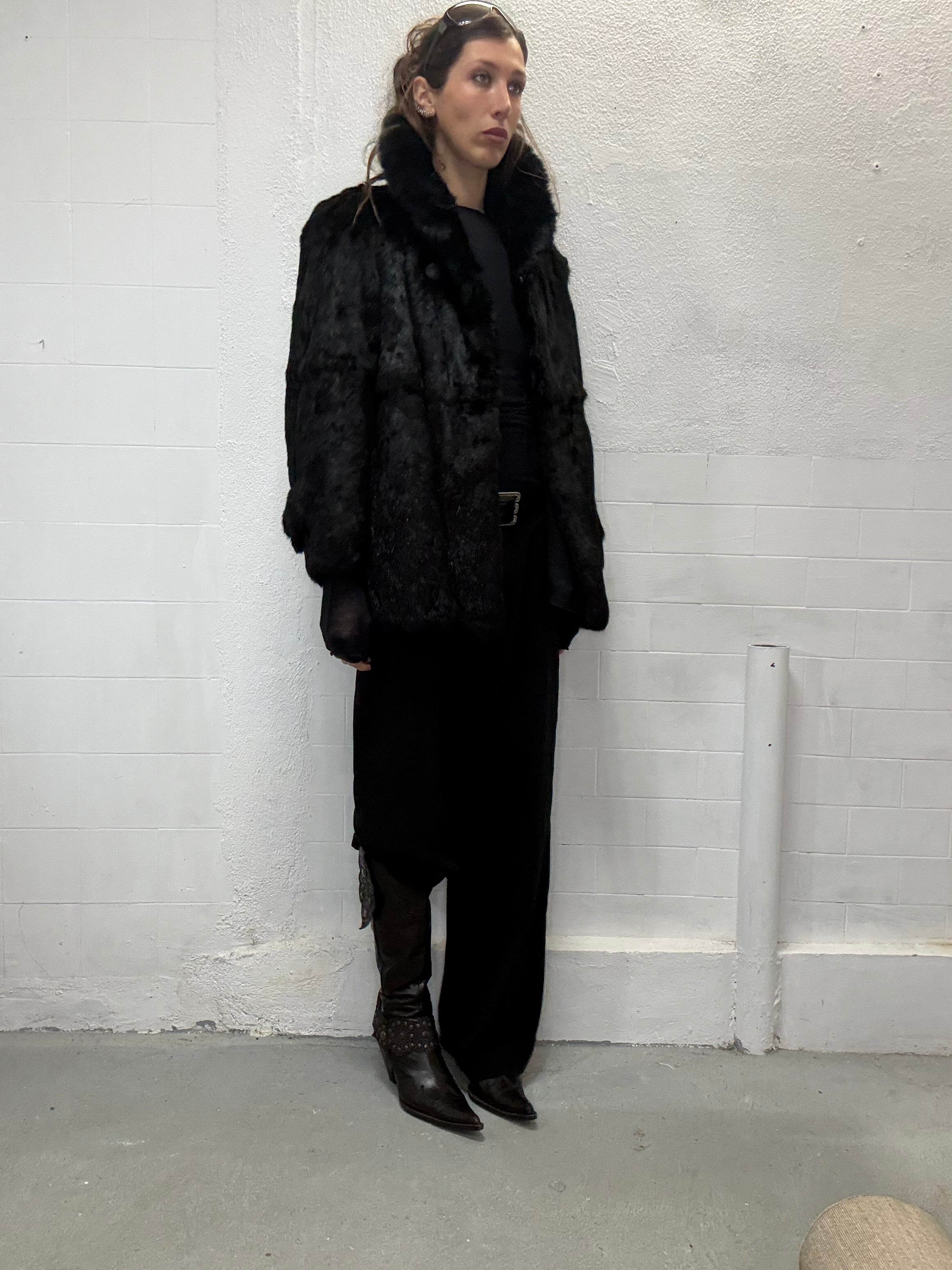 Black real fur coat with soft texture and oversized silhouette worn by model