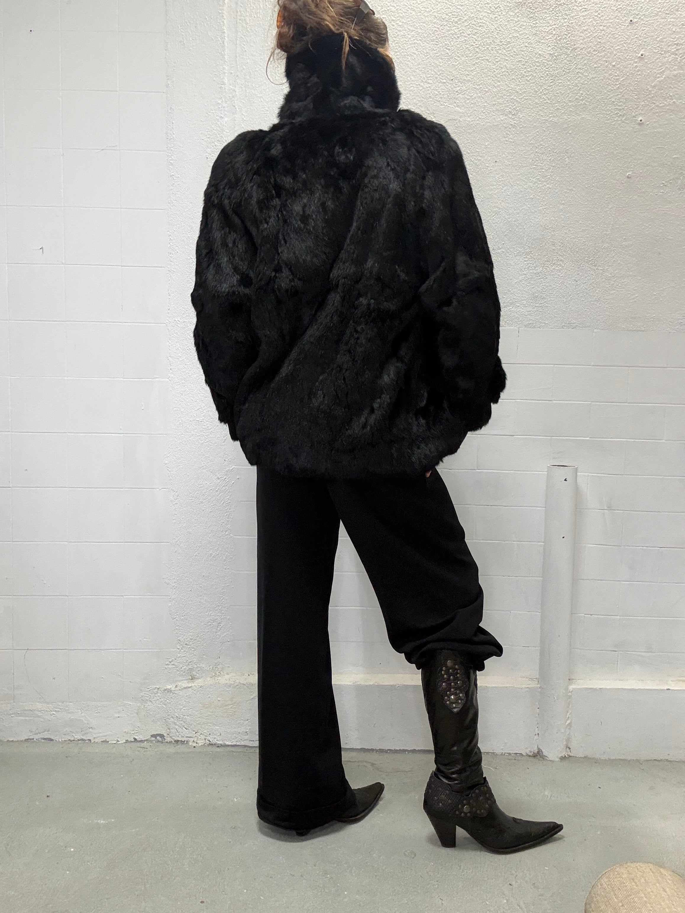 Vintage black fur coat styled in minimalist editorial setting back view
