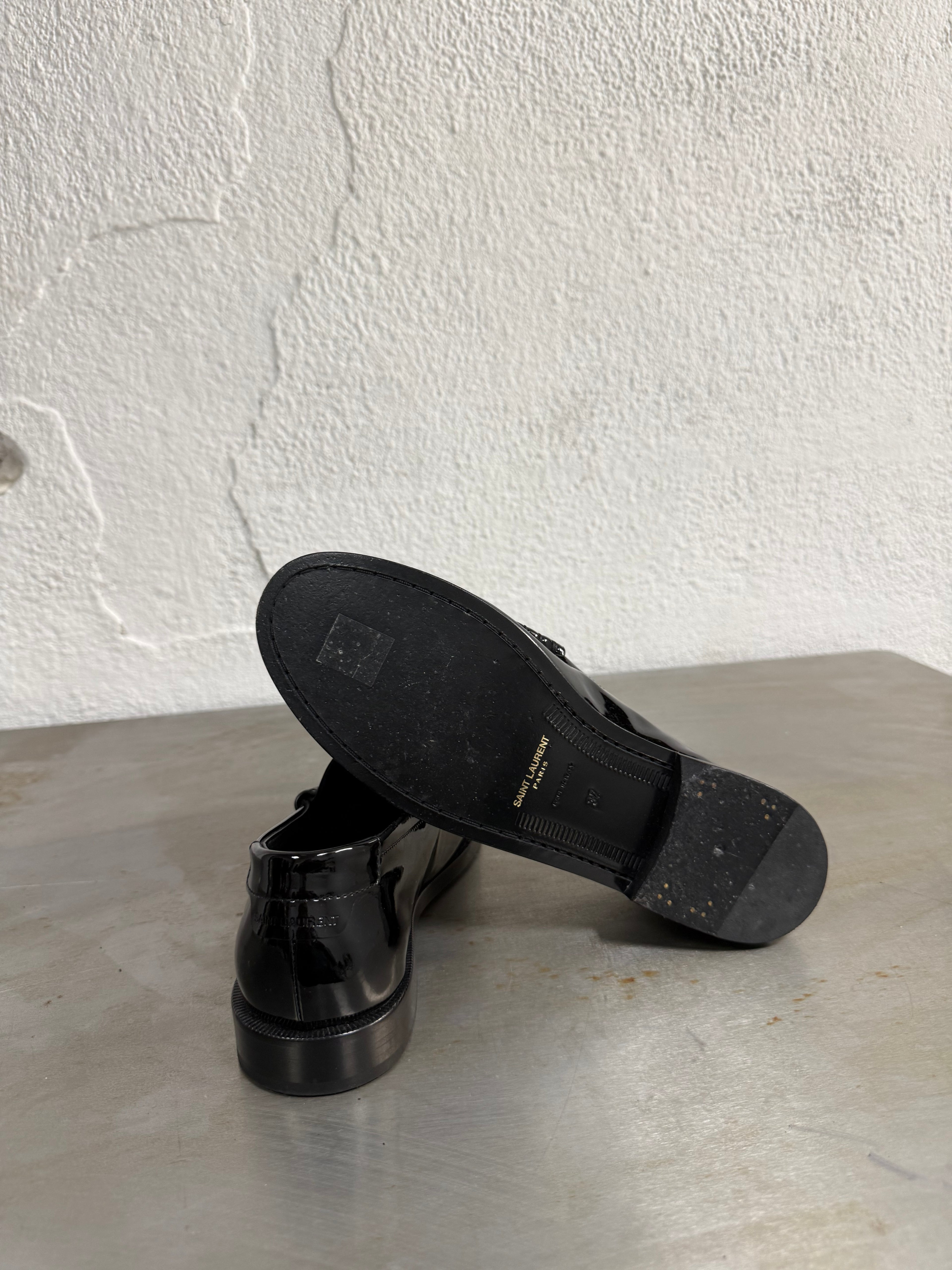 Glossy black leather loafers minimalist shot
